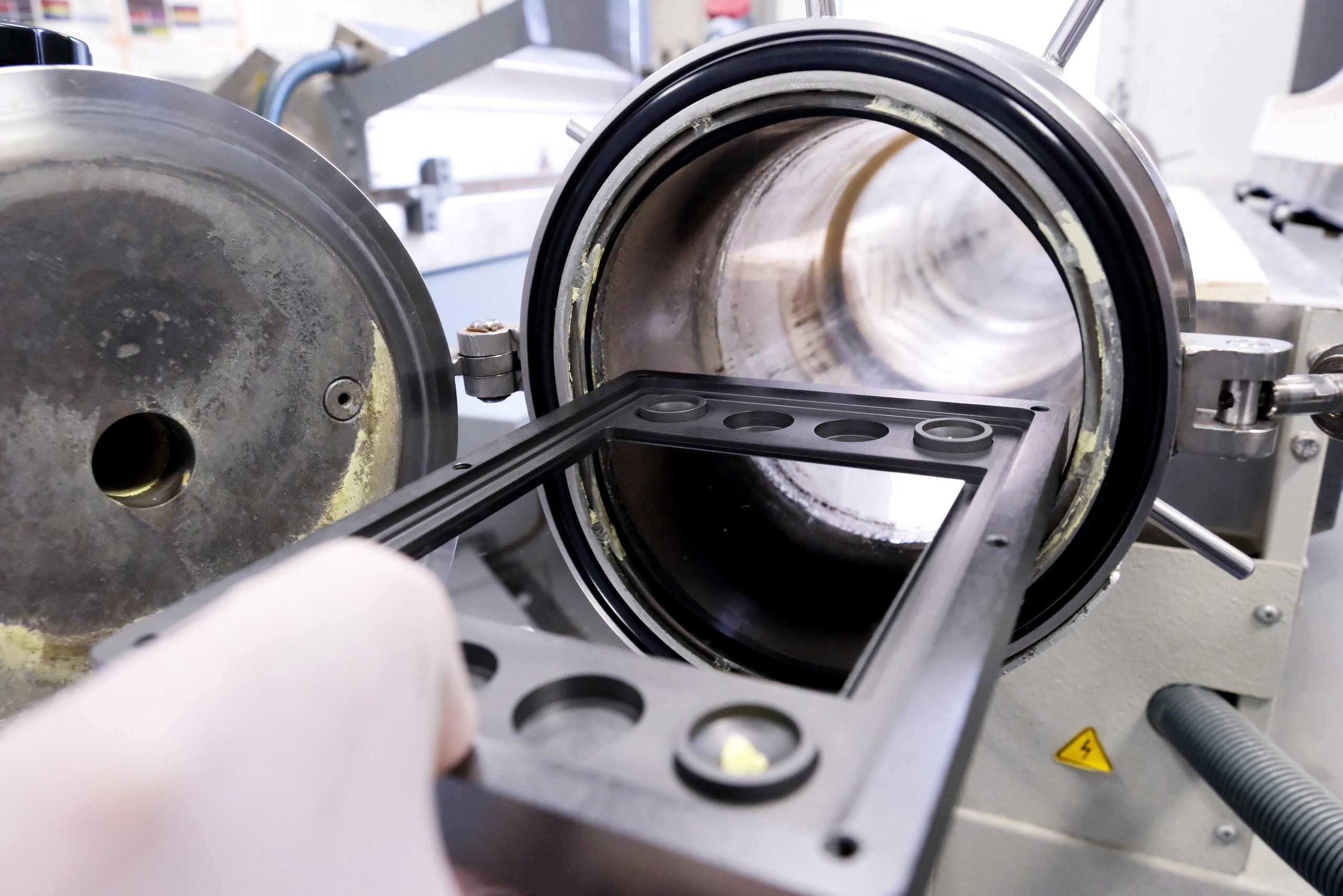 Laboratory instrument resembling a lens used for advanced materials characterization, representing multimodal analysis techniques combining spectroscopy, imaging and electrical measurements for thin-film device research.