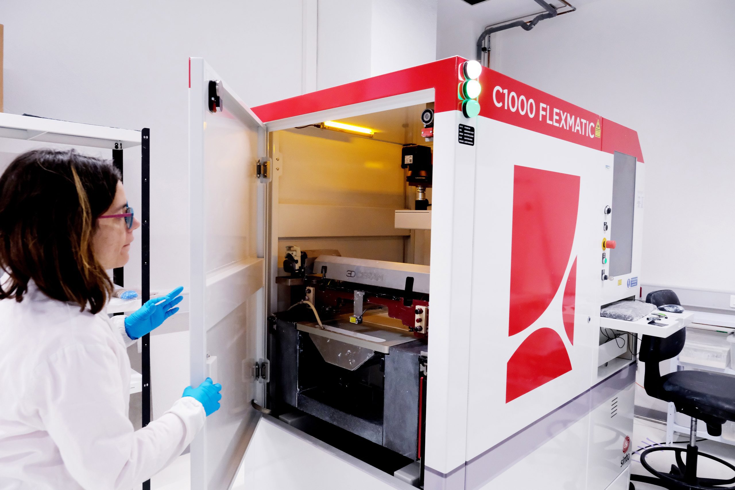 Scientist operating a ceramic 3D printer in a laboratory for additive manufacturing of solid-state energy devices, enabling scalable production of advanced battery and fuel cell architectures.