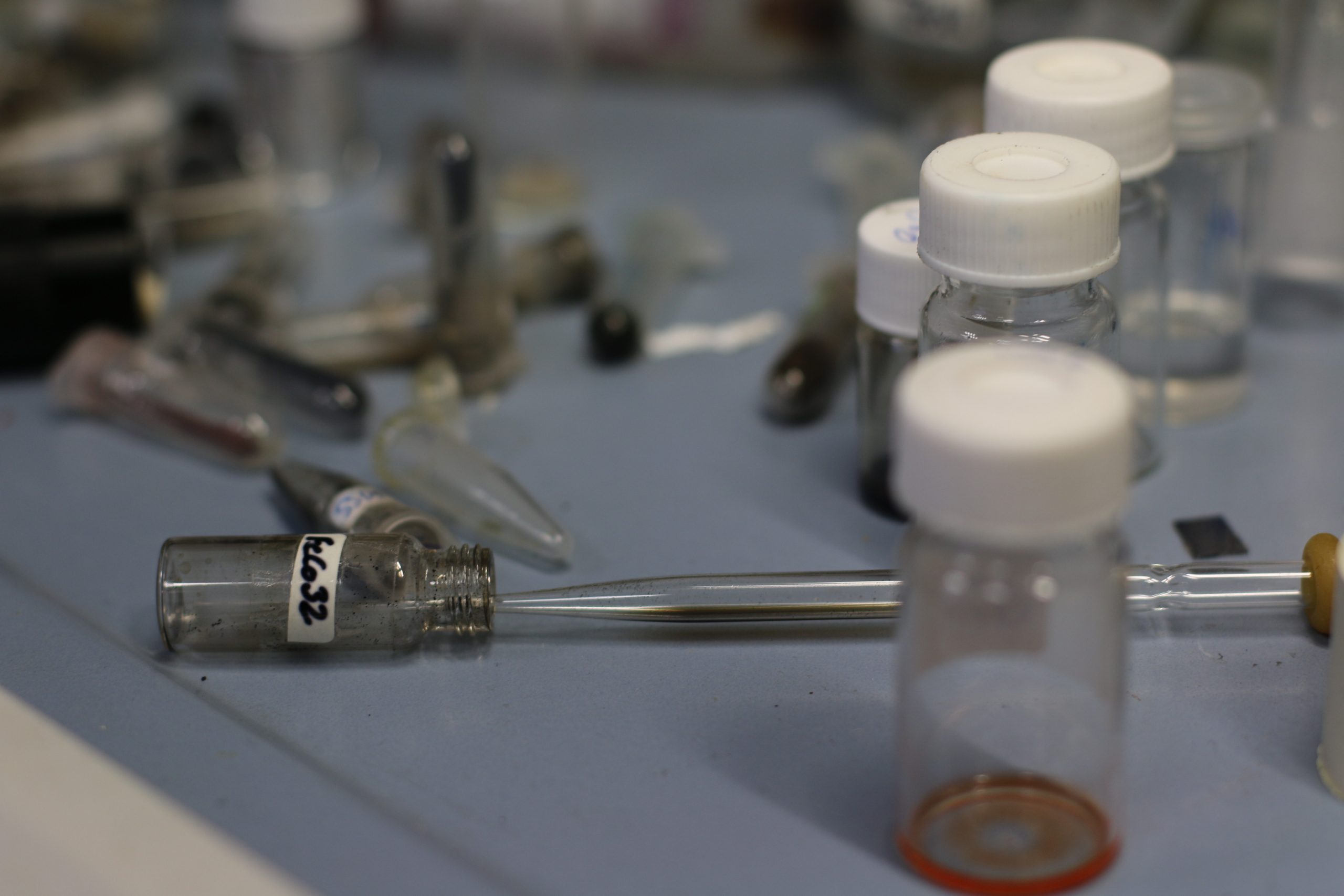 Assorted laboratory vials and equipment, representing nanoparticle ink processing and advanced material fabrication for thin films, nanocomposites and microdevice development.