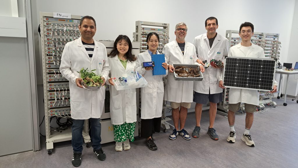 Researchers in a battery laboratory holding reused, recycled and surplus materials related to circular battery production