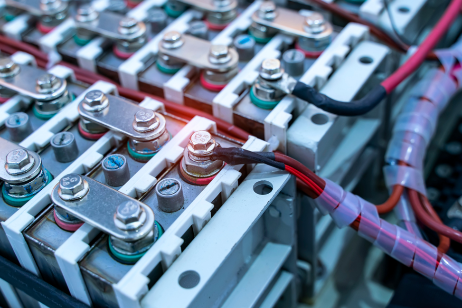 Close-up of battery cells connected by metal busbars and electrical cables.